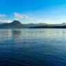 A panoramic shot of a tranquil lake toba reflecting the blue sky